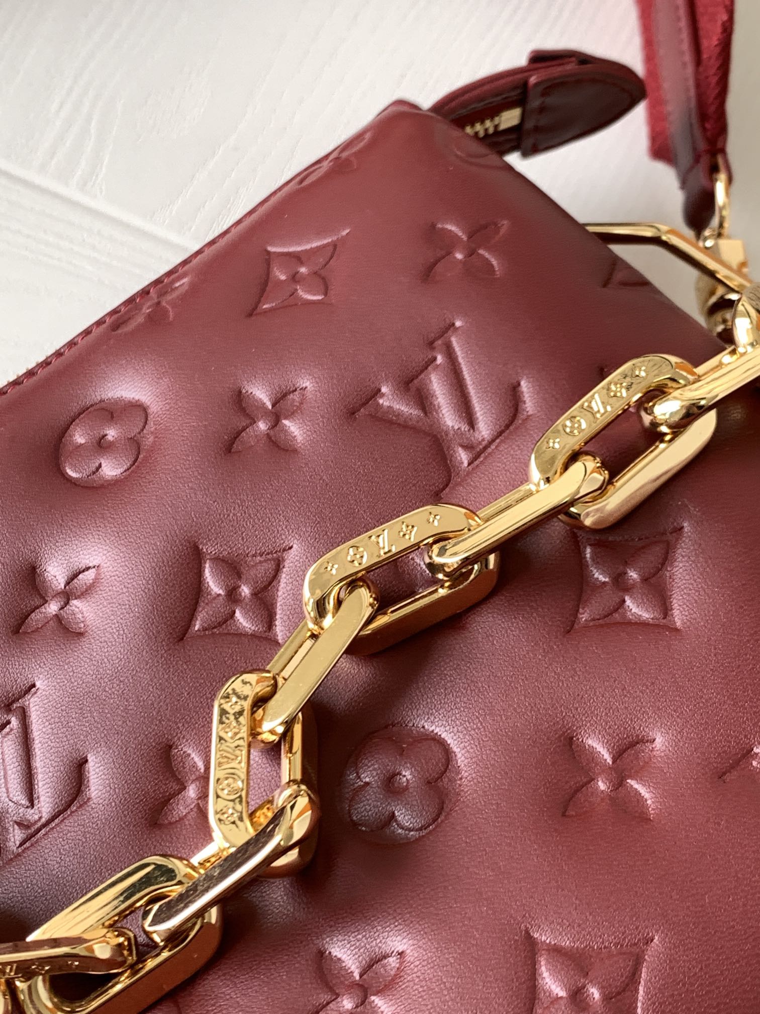 Louis Vuitton Elegant Burgundy Embossed Crossbody Bag with Wide Fabric Strap