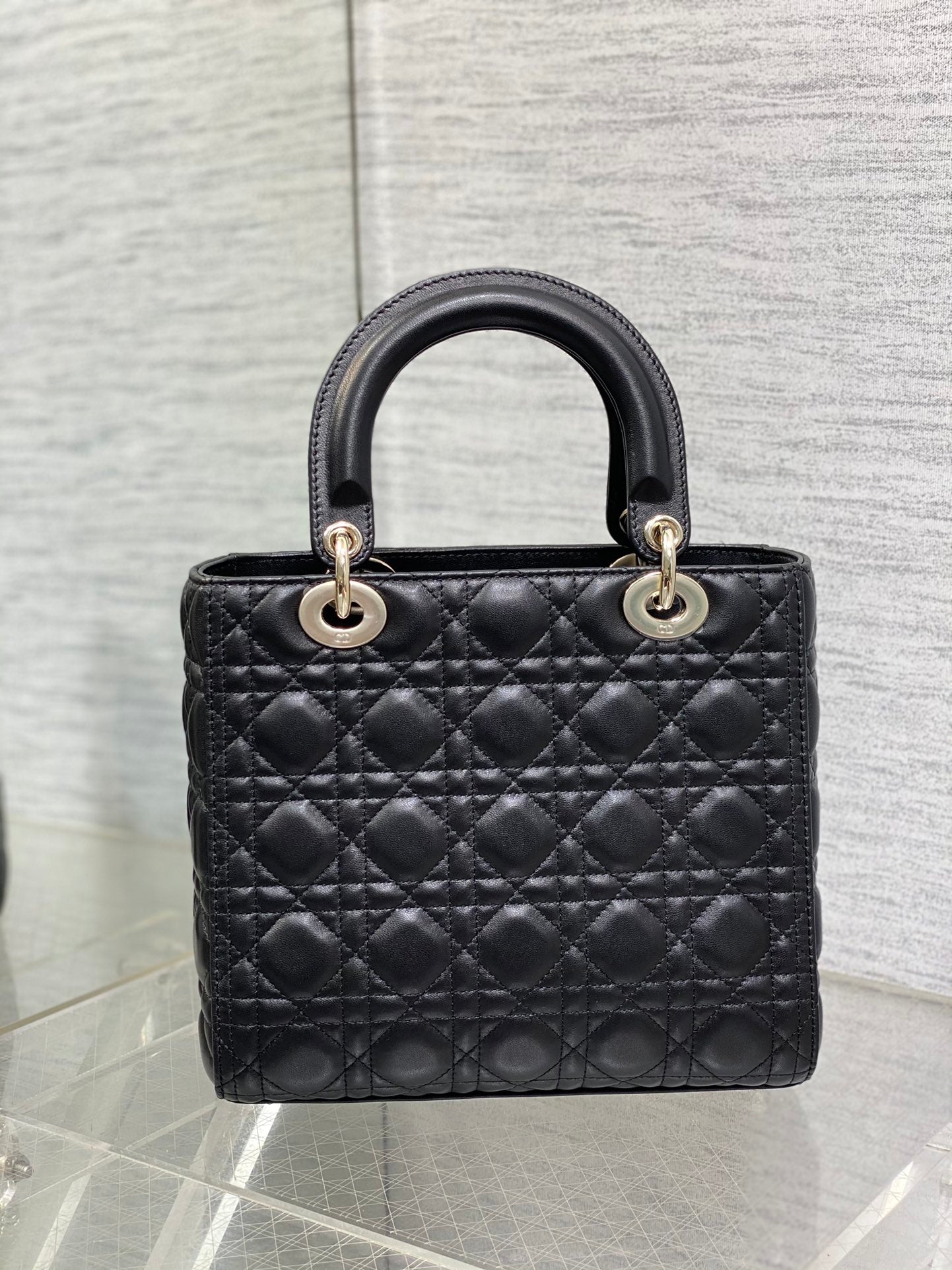 Dior Elegant Black Quilted Leather Handbag with Top Handle and Gold Charms