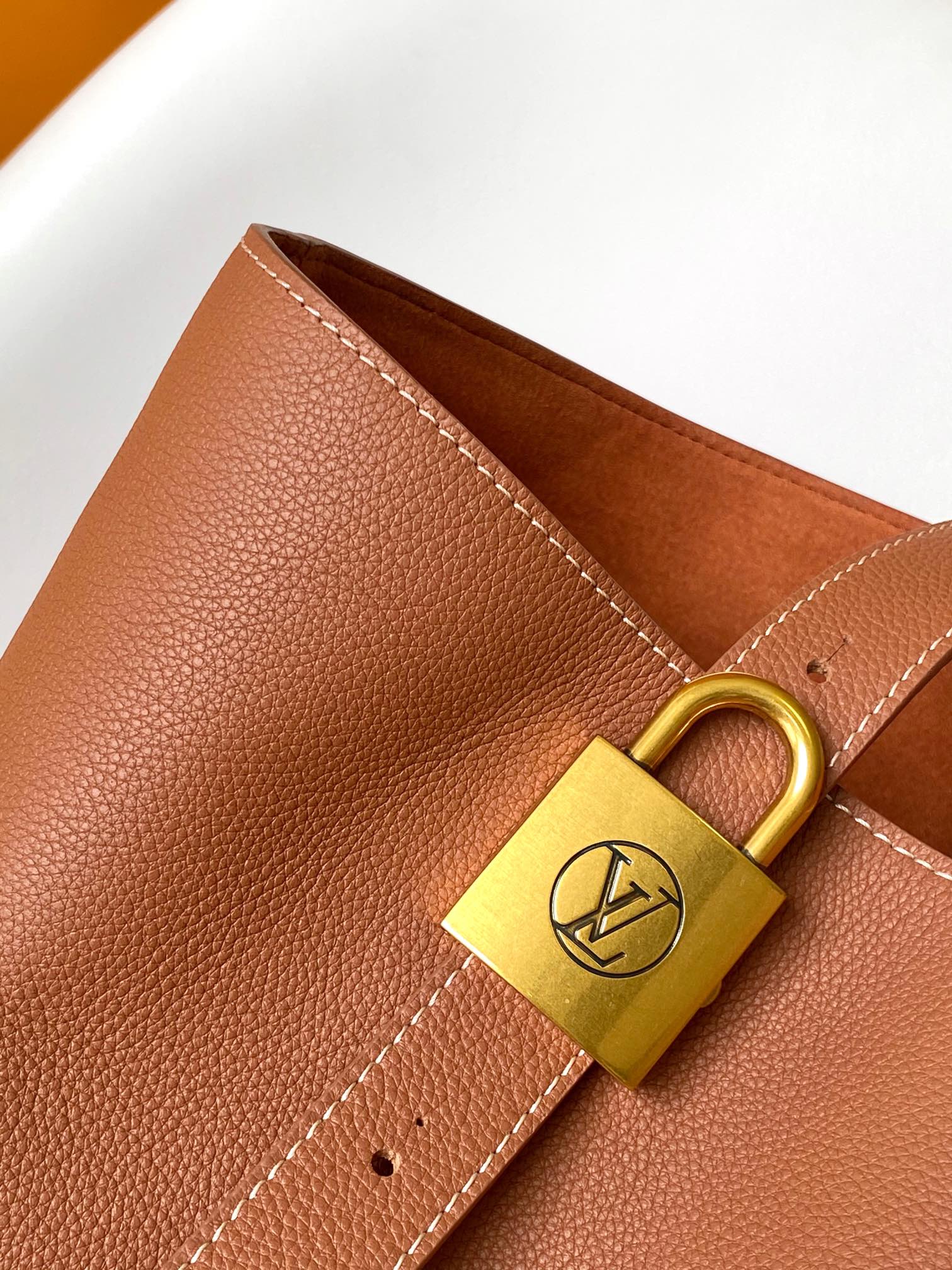 Louis Vuitton Classic Brown Leather Tote Bag with Gold Lock Accent and Shoulder Straps